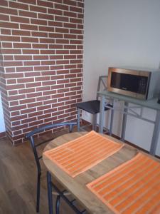 a room with a table and a chair and a microwave at Apartament Boguslawskiego in Przemyśl