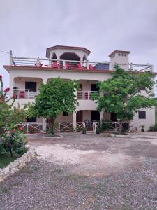 a large white building with trees in front of it at Eliwes Villa in Treasure Beach