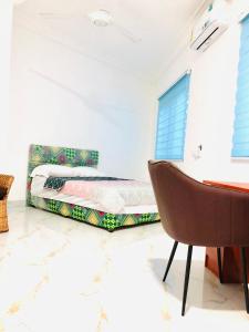 ElminaにあるMavern House Apartmentsのベッドルーム1室(ベッド1台、椅子付)