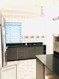 eine Küche mit schwarzen Schränken und einem Fenster in der Unterkunft Mavern House Apartments in Elmina