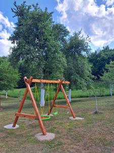a playground with a swing set in a park at Holiday house Rukavina in Donje Pazarište