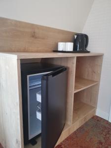 a wooden shelf with a refrigerator underneath a counter at Boutique Hotel BelleVue in Sighnaghi