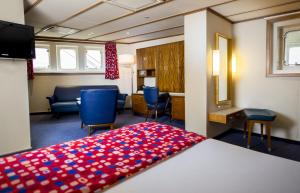 a room with a bed and chairs and a desk at ss Rotterdam by WestCord in Rotterdam +47 photos