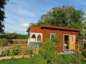 a tiny house in a garden with a fence at Piddle Puddle Cabin in Dorchester