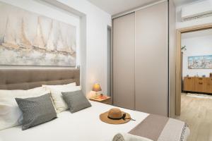 1 dormitorio con 1 cama con sombrero en ModernPastel Apartment - Near Old Port with parking en La Canea