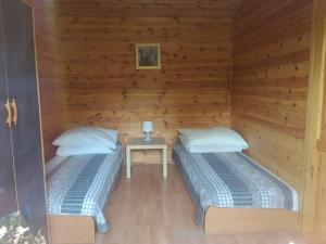 two beds in a wooden room with a table at Przy morzu in Jarosławiec