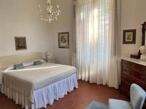 een slaapkamer met een bed en een kroonluchter bij Villa Vanna - the ancient Forte just in the center in Forte dei Marmi