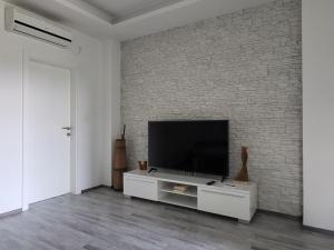 sala de estar con TV en una pared de ladrillo en Apartments Lipić, en Posedarje