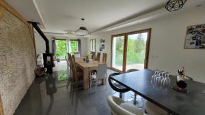 a dining room and living room with a table and chairs at Chez Lily et Bruno in Morbier