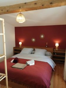 um quarto com uma cama grande e uma parede vermelha em Gîte entre mer et Cévennes em Le Cailar