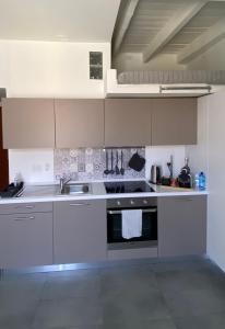 uma cozinha branca com um lavatório e um fogão em Alte Volat Casetta em Milão