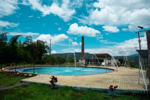 a large swimming pool with a water fountain at Glamping brisa de guadua in Moniquirá