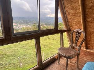 a chair sitting in front of a window at Glamping brisa de guadua in Moniquirá