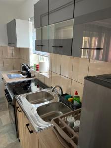 a kitchen with a sink and a refrigerator at Luka's 3 rooms apartment in Prčanj