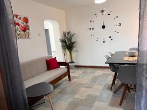 Luka's 3 rooms apartment في بريكانج: غرفة معيشة مع أريكة وساعة على الحائط