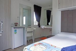 a bedroom with a bed and a table and a kitchen at Agricampeggio Ippocampo in La Cinquantina