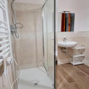 y baño con ducha y lavamanos. en Via Guareschi, en Fontanelle di Roccabianca