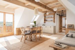 a kitchen and dining room with a table and chairs at Nowe Miejsce Brzegi in Brzegi
