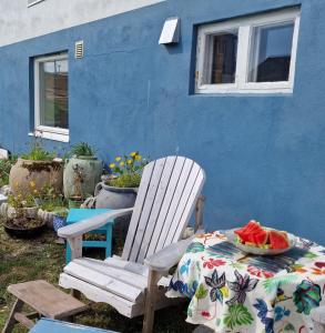 a blue house with a table and a white chair at Liten leilighet i Berlevåg in Berlevåg