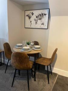 a dining room table with chairs and a table with dishes on it at Poplar House-2Bedroom house in town centre with free Parking by ShortStays4U in King's Lynn