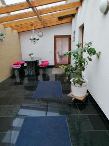 um quarto com tapetes azuis, uma mesa e um vaso de plantas em Ferienhaus Putzke em Stadtilm