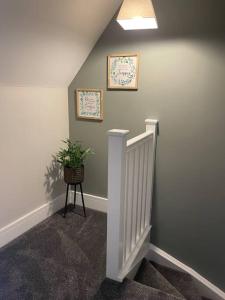 a hallway with a staircase with a potted plant on the wall at Poplar House-2Bedroom house in town centre with free Parking by ShortStays4U in Kings Lynn