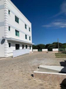 un gran edificio blanco con un patio de piedra en Novíssimo apto no melhor de São Lourenço, en São Lourenço