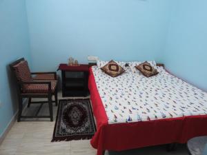 a bedroom with a bed and a chair and a table at Shanthi Villa in Coonoor