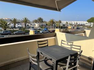 uma mesa e cadeiras numa varanda com vista para um parque de estacionamento em Residence PORT NATURE by 8-HOMES vue Port em Cap d'Agde