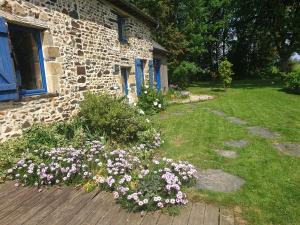a garden with flowers in front of a brick building at Ty Cœur in Bais