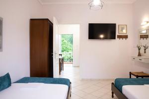 een slaapkamer met 2 bedden en een flatscreen-tv bij Evaggelia rental apartments in Skotina