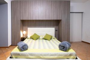 1 dormitorio con 1 cama grande con almohadas verdes en La casa sotto le cascate Lago Maggiore - IXIHOME, en Cittiglio