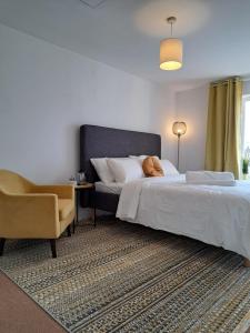 een slaapkamer met een bed en een stoel bij Luxury Rooms In Furnished Guests-Only House Free WiFi West Thurrock in Grays Thurrock