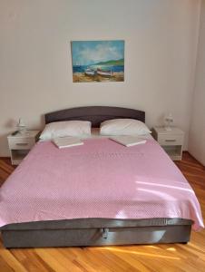 1 dormitorio con 1 cama rosa y 2 mesitas de noche en Ruža i Natalija en Karlobag