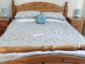 uma cama com uma moldura de madeira e uma almofada azul em Mountshade em Finzean