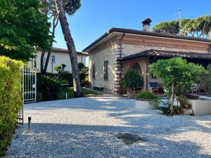 a house with a gate and a gravel driveway at Villa Vanna - the ancient Forte just in the center in Forte dei Marmi