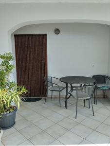 a patio with a table and chairs and plants at Ruža i Natalija in Karlobag +9 photos