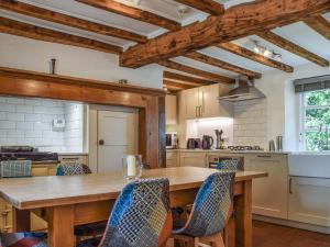 Adstock的住宿－Wayside Cottage，厨房配有木桌和椅子