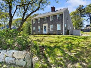 una casa en una colina con un patio de césped en 180 Hardings Beach Road Chatham Cape Cod - The Cape Escape, en Chatham