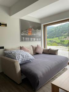 a large bed in a room with a large window at Burg Anna in Telfes im Stubai