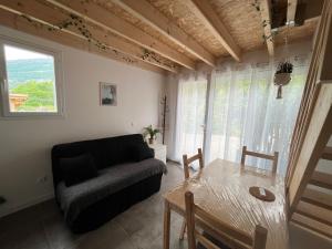 un soggiorno con divano e tavolo di Petit Fare Rochois avec mezzanine a La Roche-des-Arnauds