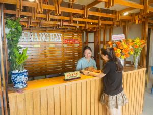 Dos mujeres de pie en un mostrador en un restaurante en DA NANG BAY HOTEL, en Da Nang
