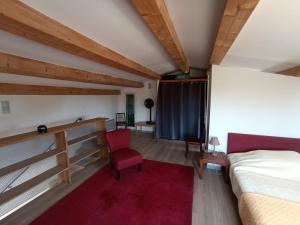 1 dormitorio con 1 cama y 1 silla roja en Maison Manosque, en Manosque