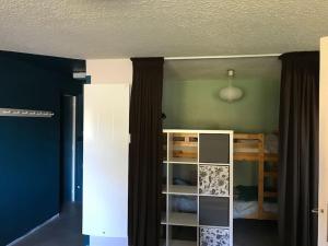 une chambre avec un lit et une étagère dans l'établissement Appartement spacieux au cœur du massif du Sancy, à Le Mont-Dore