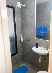 ein Badezimmer mit Waschbecken, Toilette und Spiegel in der Unterkunft Lux Suites Tsavo Studios Embakasi in Nairobi + 42 Fotos