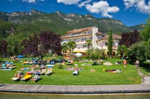 Un groupe de personnes se posant sur l'herbe près d'un hôtel dans l'établissement Seegarten, à Caldaro