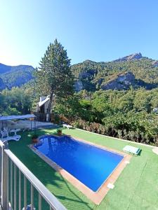 una piscina en un balcón con montañas en el fondo en Alojamiento Rural Mariola en La Iruela