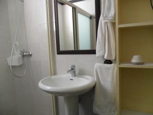 a bathroom with a white sink and a mirror at La Stanza Alternativa in Sannicola
