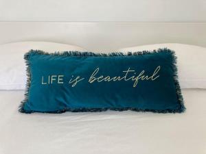 ein blaues Kissen mit den Worten Das Leben ist schön in der Unterkunft Gafa House - Family Accommodation and Workplace in Gafanha da Nazaré