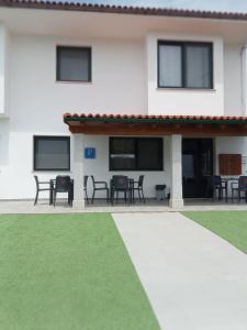 una casa con patio arredato con tavoli e sedie di Pension Xacobeo Lavacolla a Lavacolla